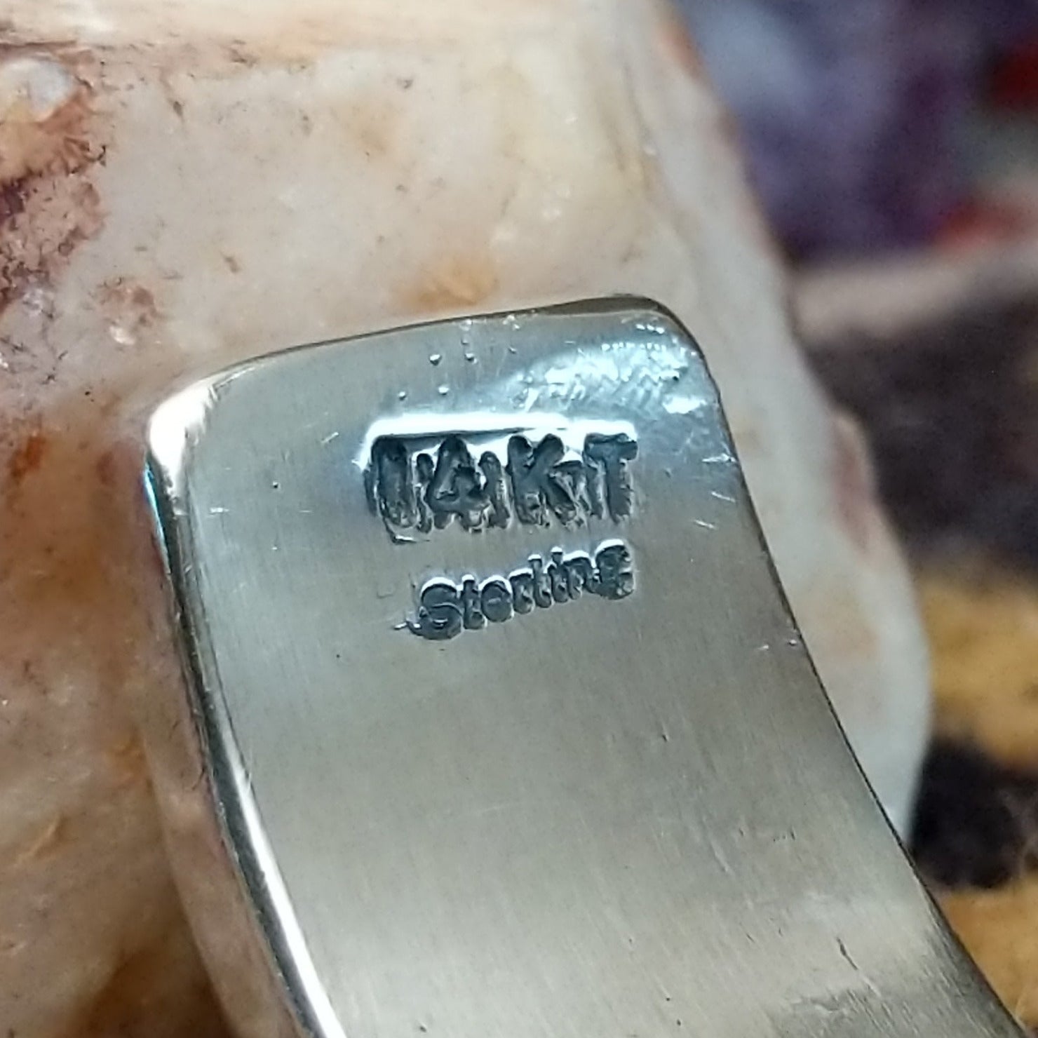 Close up of stamped 14KT and Sterling, indicating 14 karat gold and sterling silver construction.