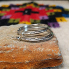 Silver angular hoop earrings by Verna Tahe.