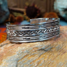 Silver cuff by Sunshine Reeves with two stamped arrows and central repeating diamond pattern.