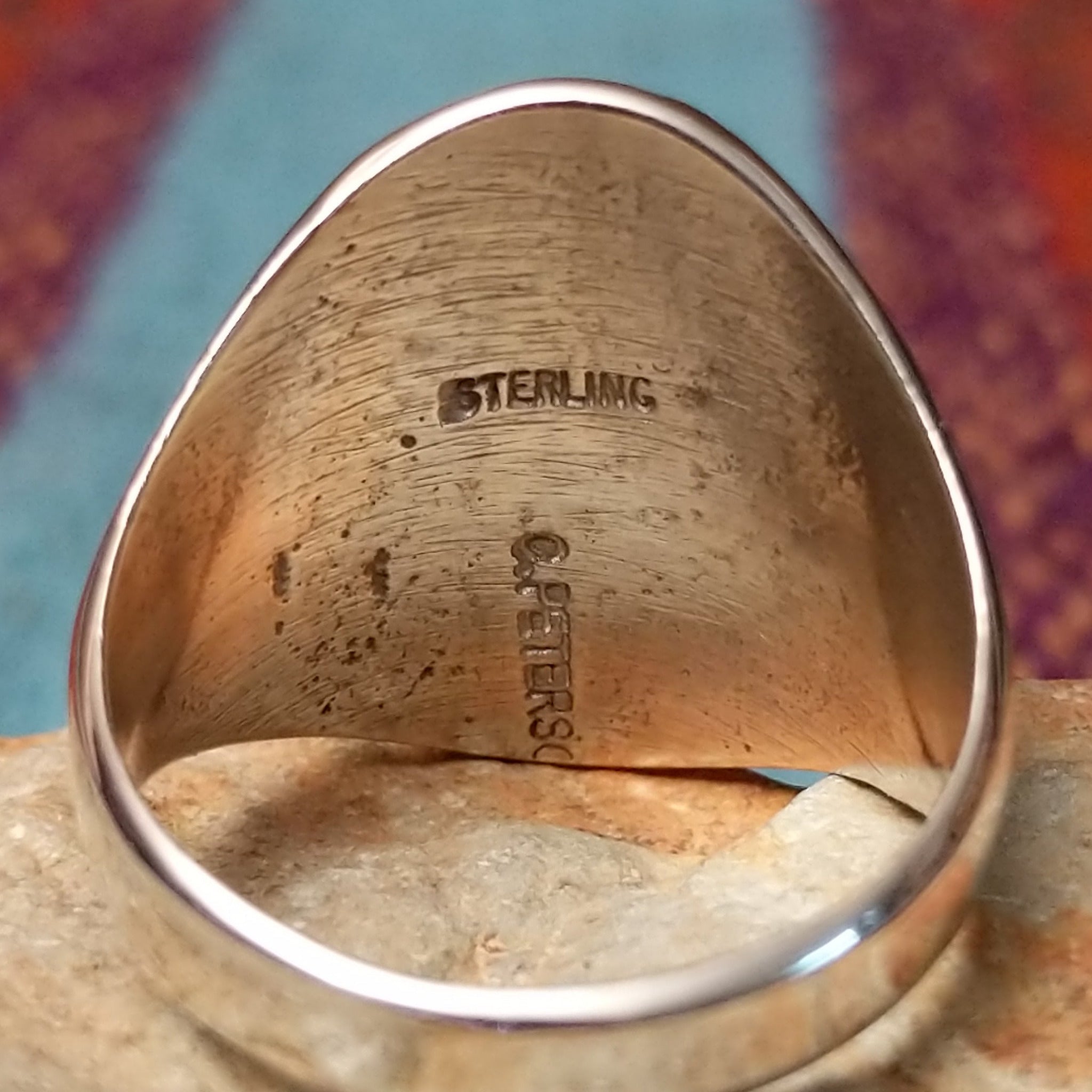 Silver Bison Ring by Calvin Peterson featuring a raised bison motif with geometric detailing, darkened recessed accents, and a polished Sterling Silver oval face and band; artisan and Sterling Silver stamp.