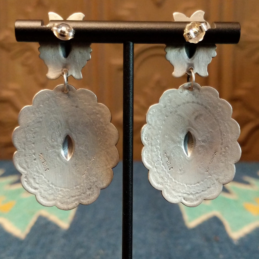 The back of the earrings feature the artisan's stamped signature.