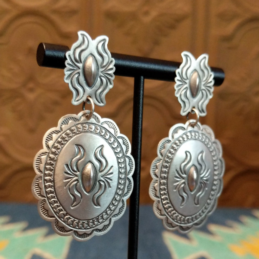 Silver concho earrings with intricate details.