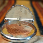 Silver Concho Ring by Elgin Tom featuring an oval silver concho with radiating stamped patterns, a raised diamond-shaped center, scalloped edges, and contrasting oxidized detailing; artisan and Sterling Silver stamp.