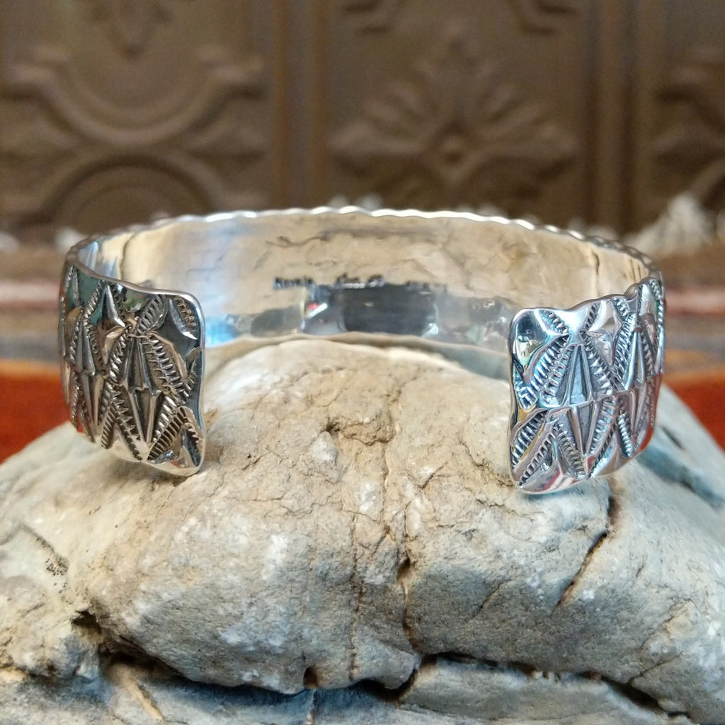 Sterling silver cuff with stamped diamond designs and polished finish.