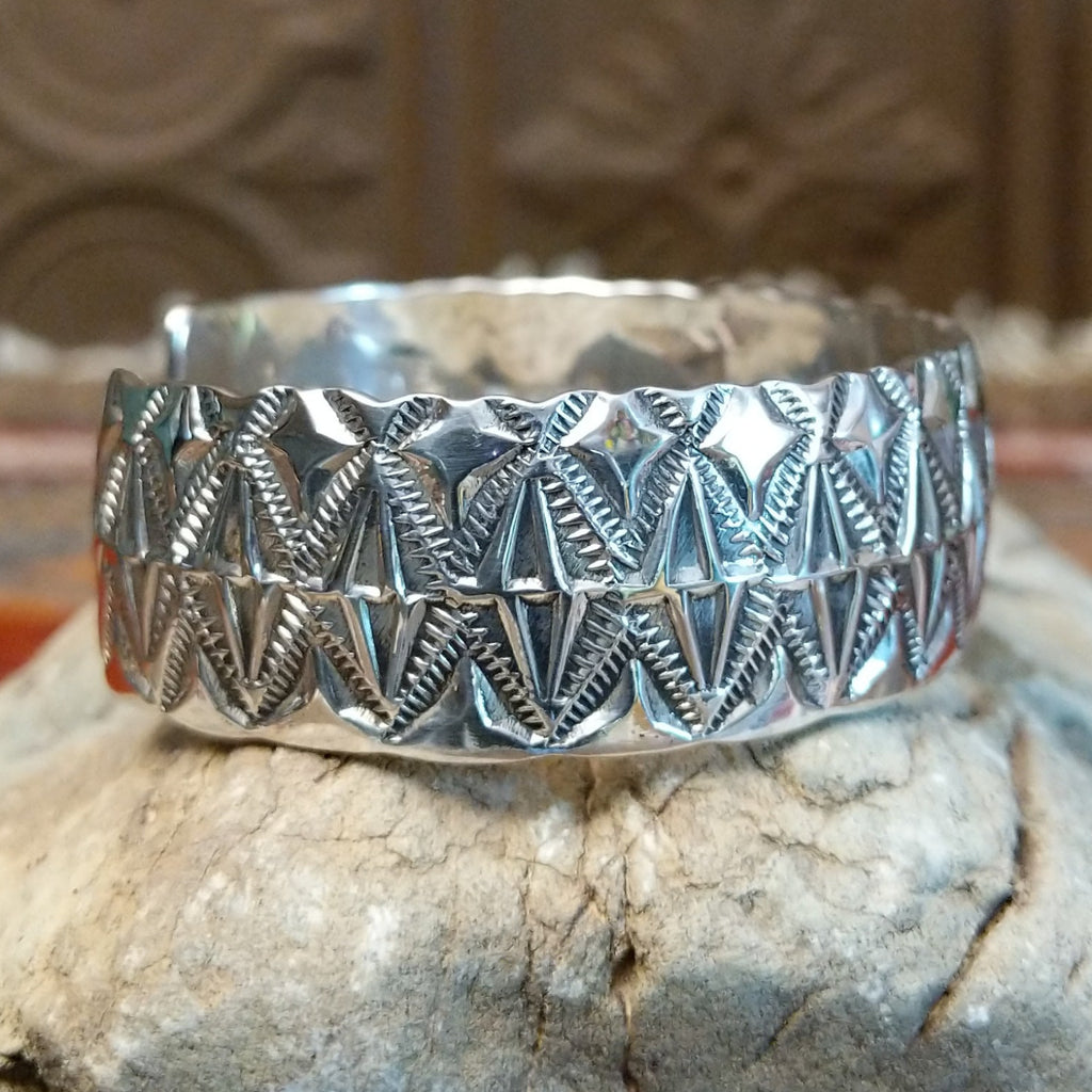Sterling silver cuff with stamped diamond designs and polished finish.