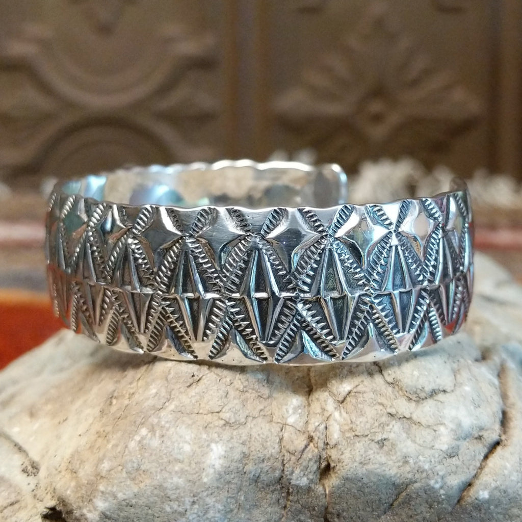 Sterling silver cuff with stamped diamond designs and polished finish.