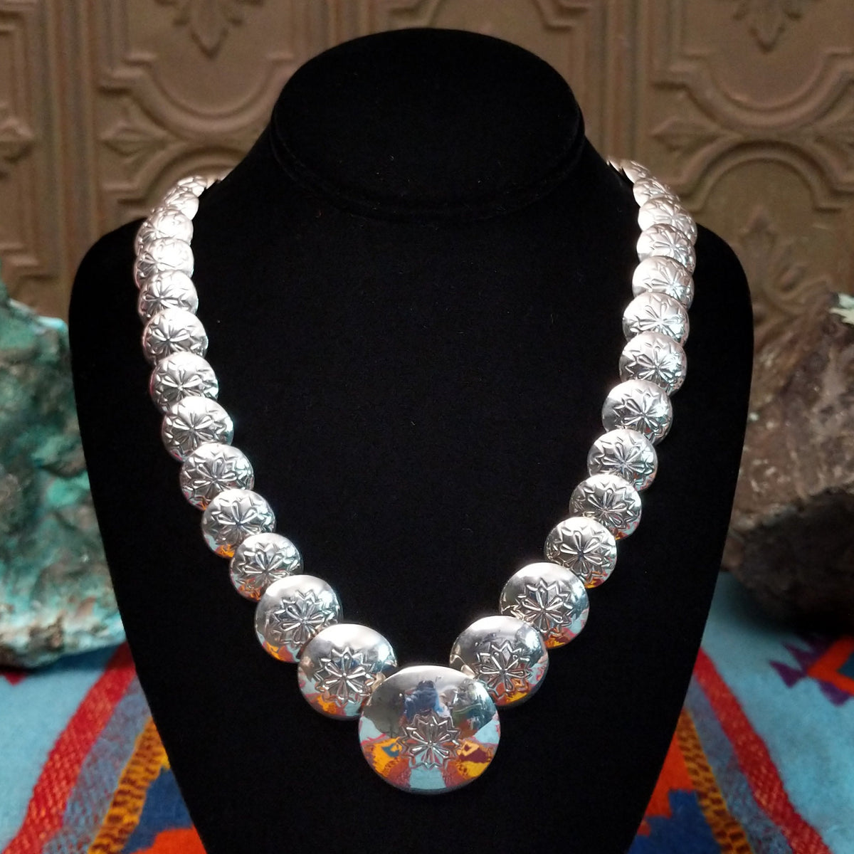 Silver Disc Necklace by Carol Smith with graduated domed discs and repeating stamped floral designs.