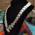 Silver Disc Necklace by Carol Smith with graduated domed discs and repeating stamped floral designs.