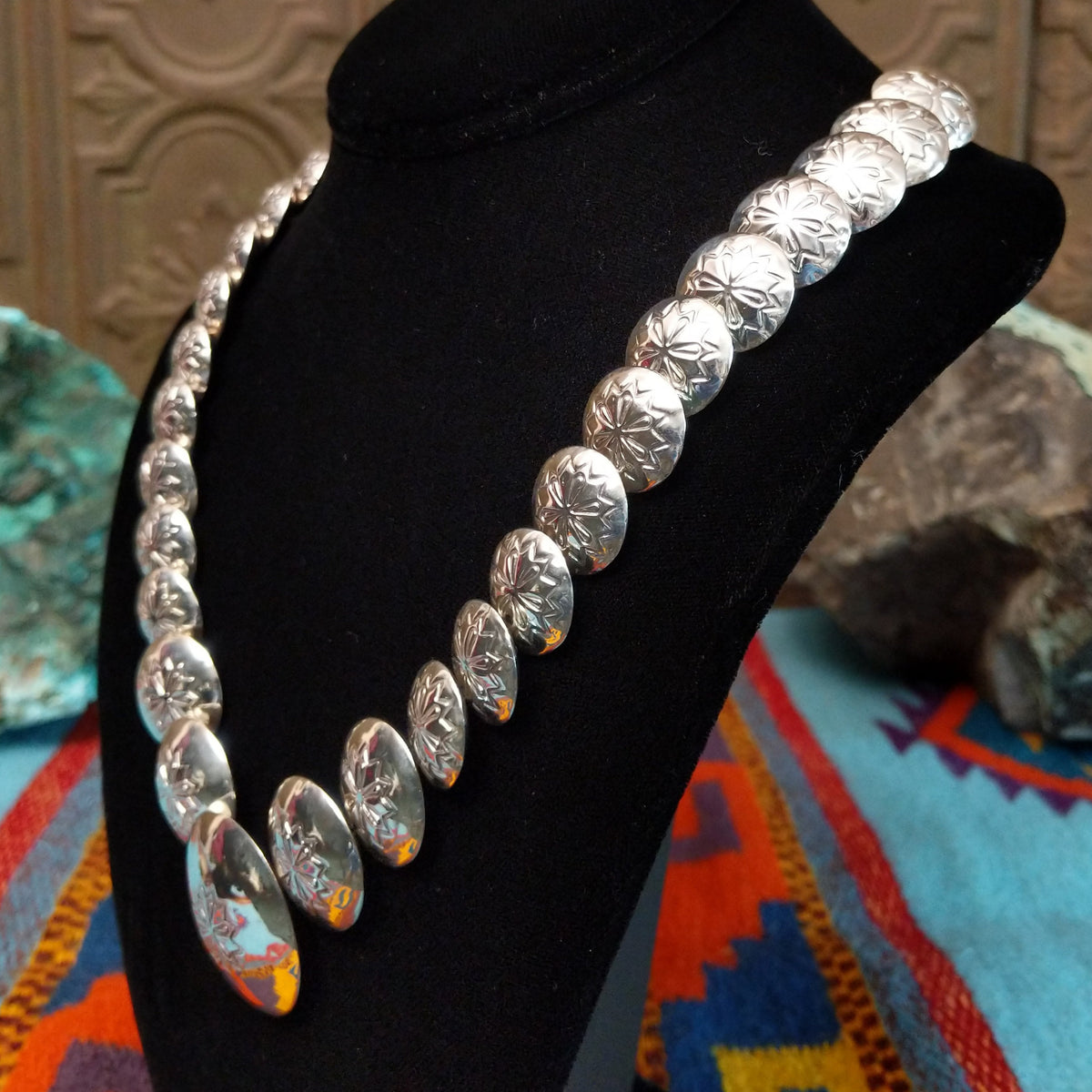 Silver Disc Necklace by Carol Smith with graduated domed discs and repeating stamped floral designs.