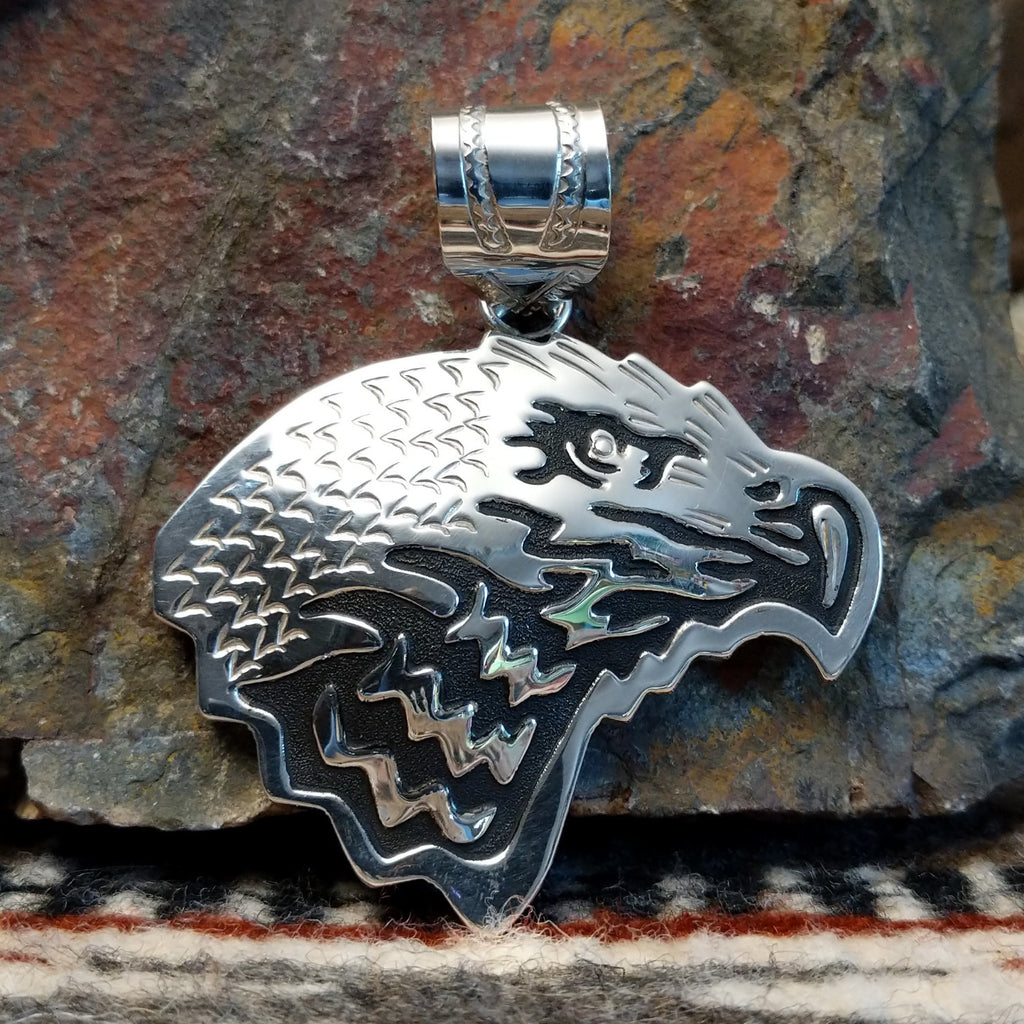Sterling silver eagle head pendant and polished finish.