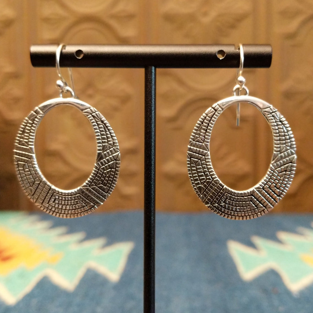 Sterling silver earrings crafted into eclipse silhouettes with geometric stamping.