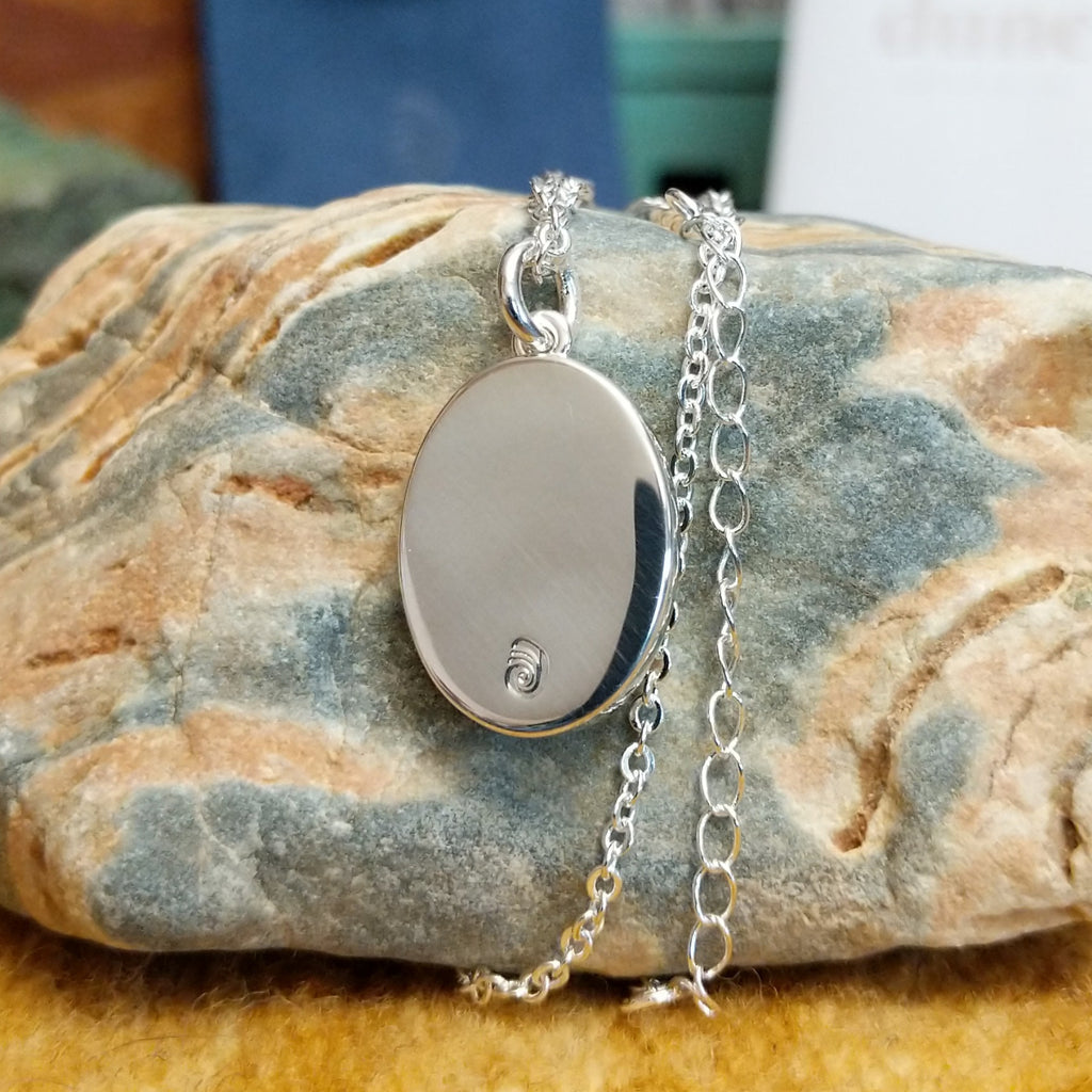 Silver-plated brass backing with the maker's trademark.