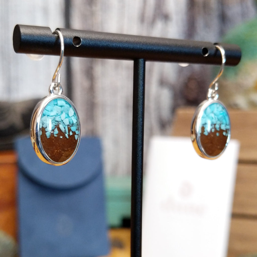 Oval earrings with a silver-plated brass frame, featuring turquoise and sand.