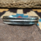 Silver feather cuff by Angela Martin, featuring a handcrafted sterling silver feather design with engraved details and traditional Southwestern craftsmanship.