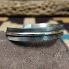 Silver feather cuff by Angela Martin, featuring a handcrafted sterling silver feather design with engraved details and traditional Southwestern craftsmanship.