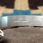 Silver feather cuff by Angela Martin, featuring a handcrafted sterling silver feather design with engraved details and traditional Southwestern craftsmanship.  Artisan and Sterling Silver stamp.