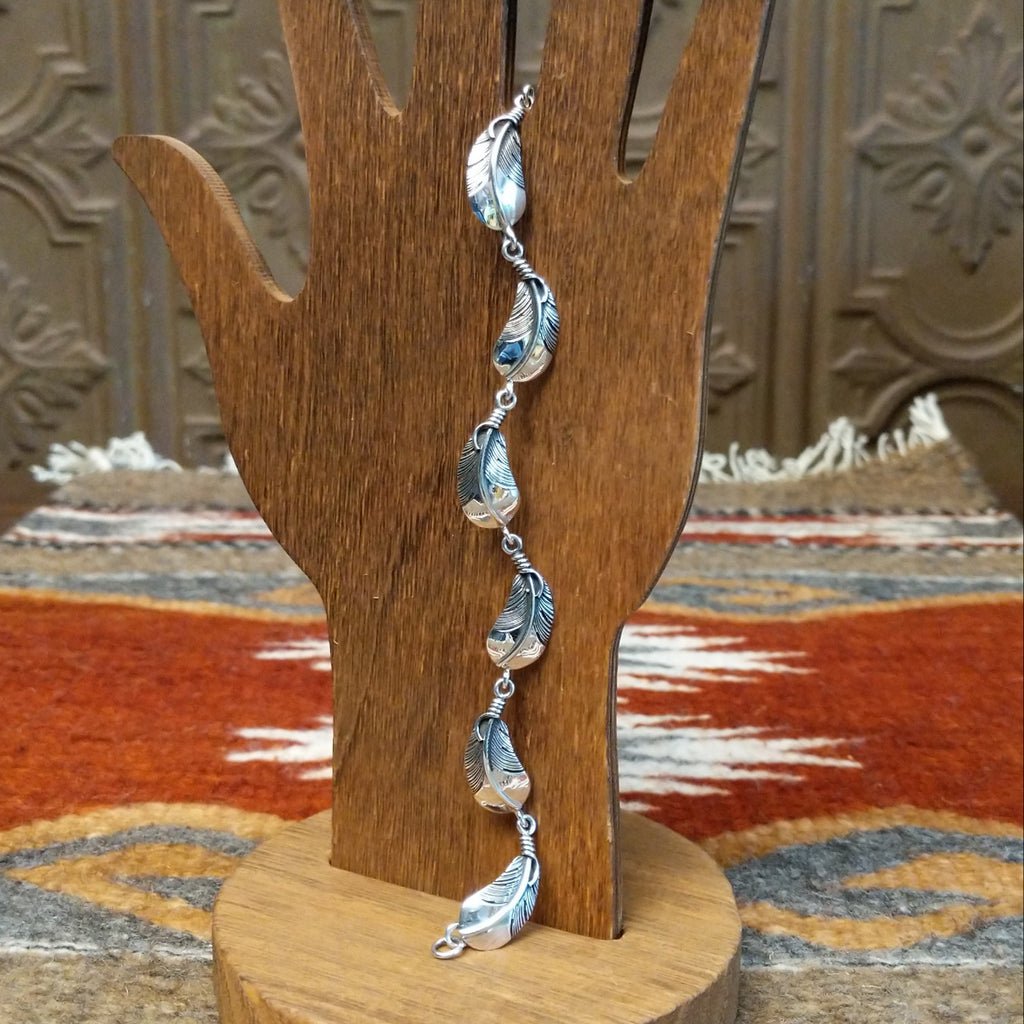 Sterling silver feather link bracelet with polished finish.