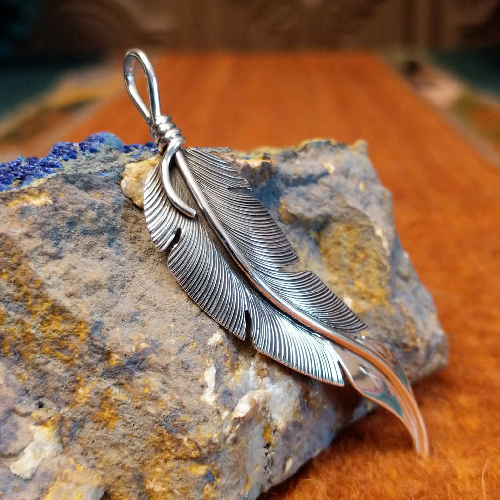 Sterling silver curved feather pendant.