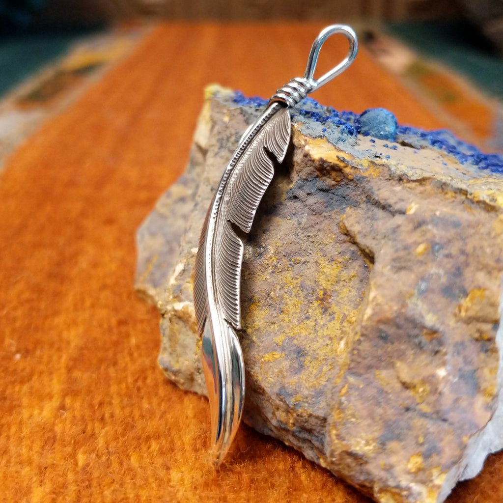 Sterling silver curved feather pendant.