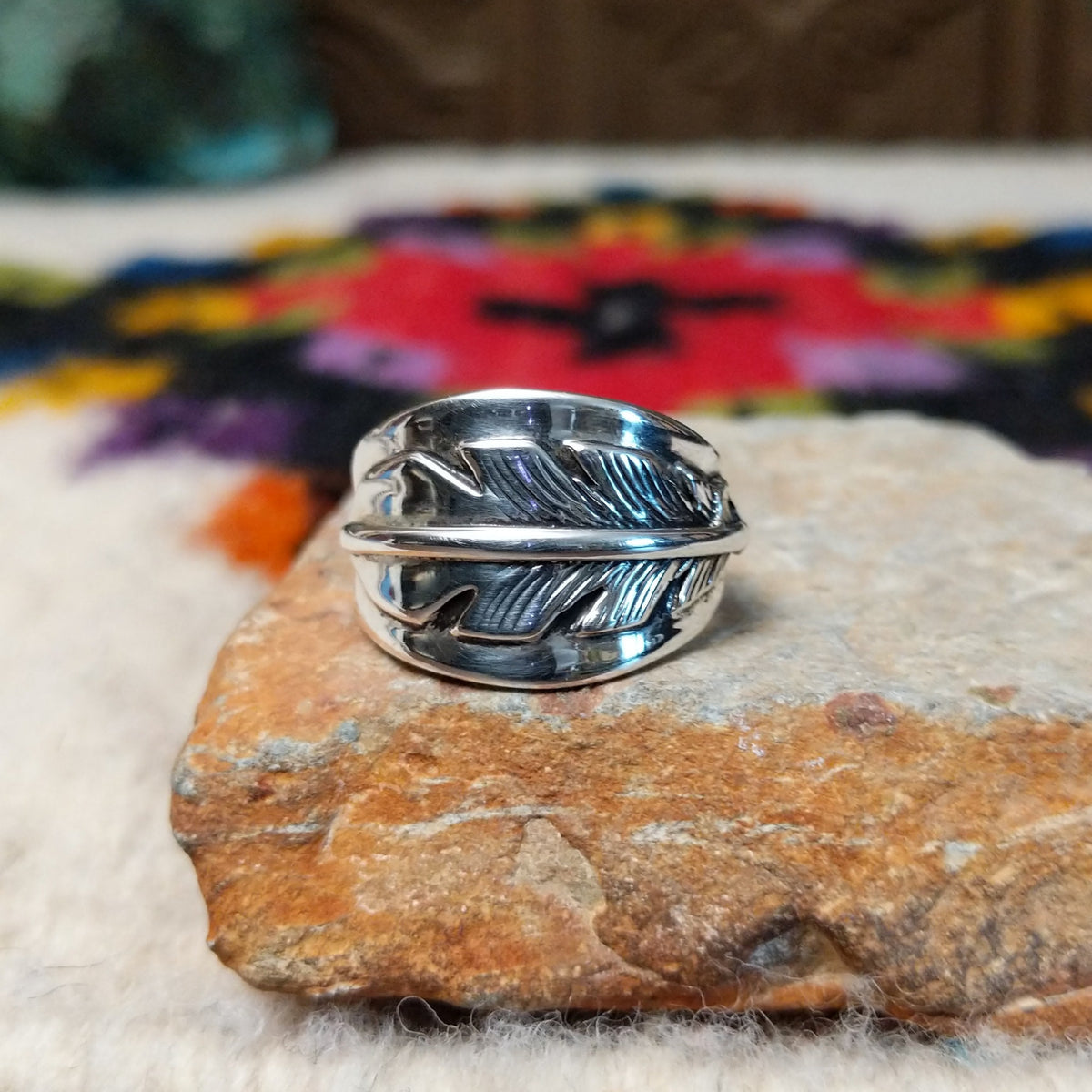 Wide silver feather ring by L.P. with detailed stamped lines and a raised center spine.