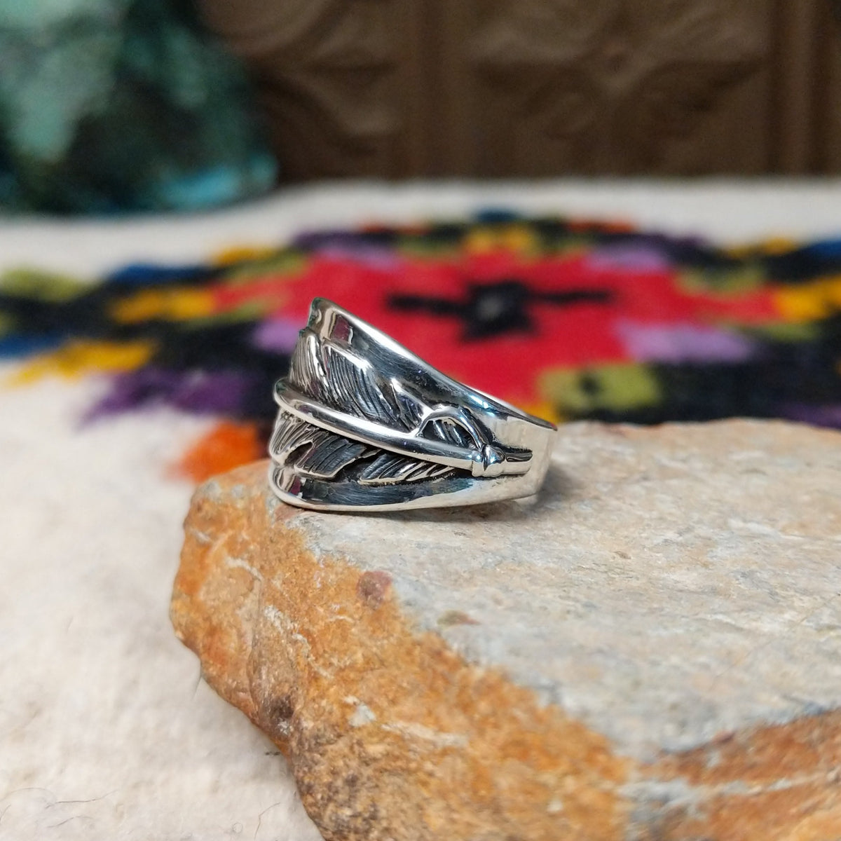 Wide silver feather ring by L.P. with detailed stamped lines and a raised center spine.