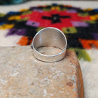 Wide silver feather ring by L.P. with detailed stamped lines and a raised center spine.