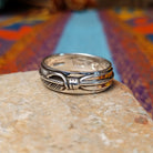 Silver Feather Ring by Raymond Coriz featuring a continuous detailed feather pattern with textured lines, darkened accents, and polished Sterling Silver borders.