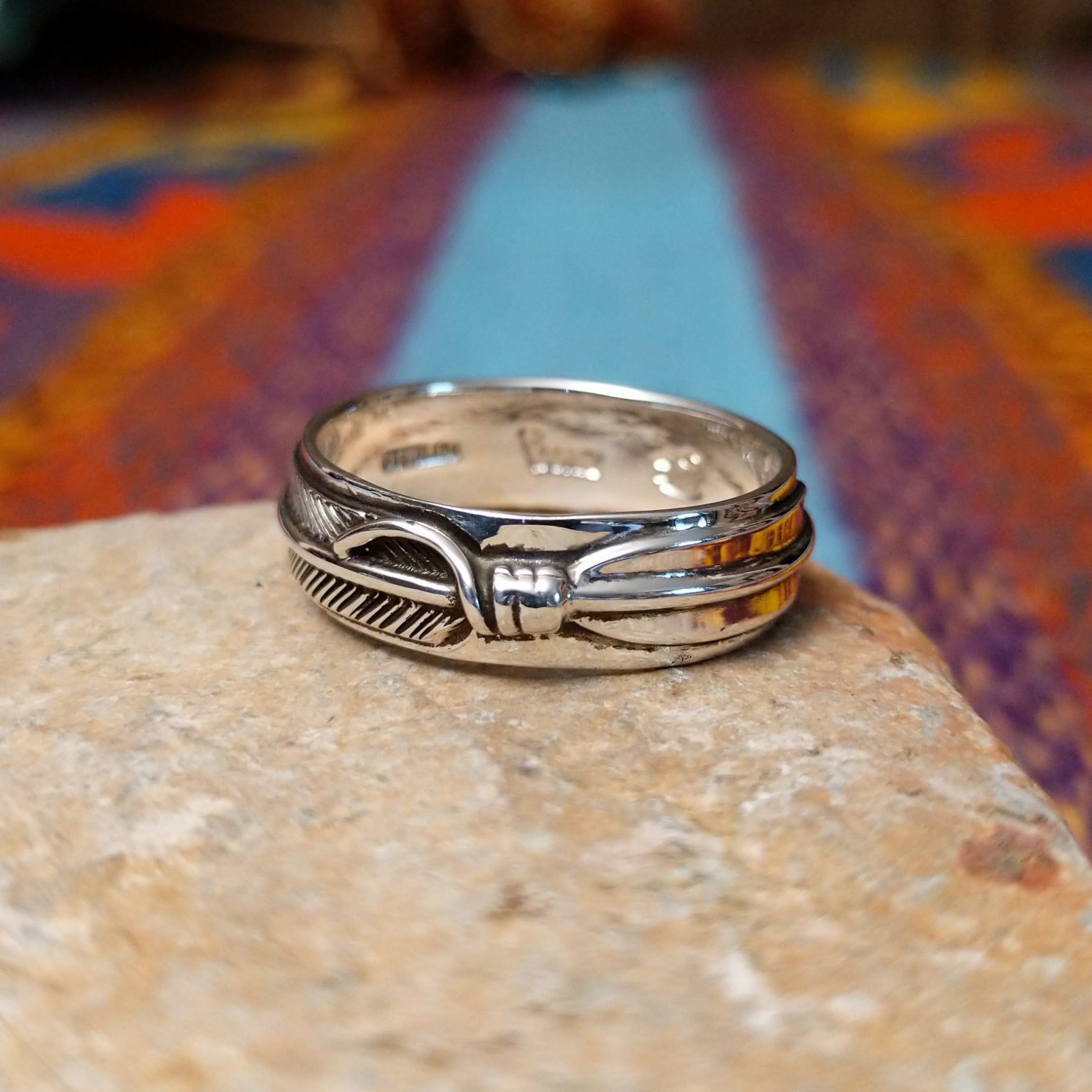 Silver Feather Ring by Raymond Coriz featuring a continuous detailed feather pattern with textured lines, darkened accents, and polished Sterling Silver borders.