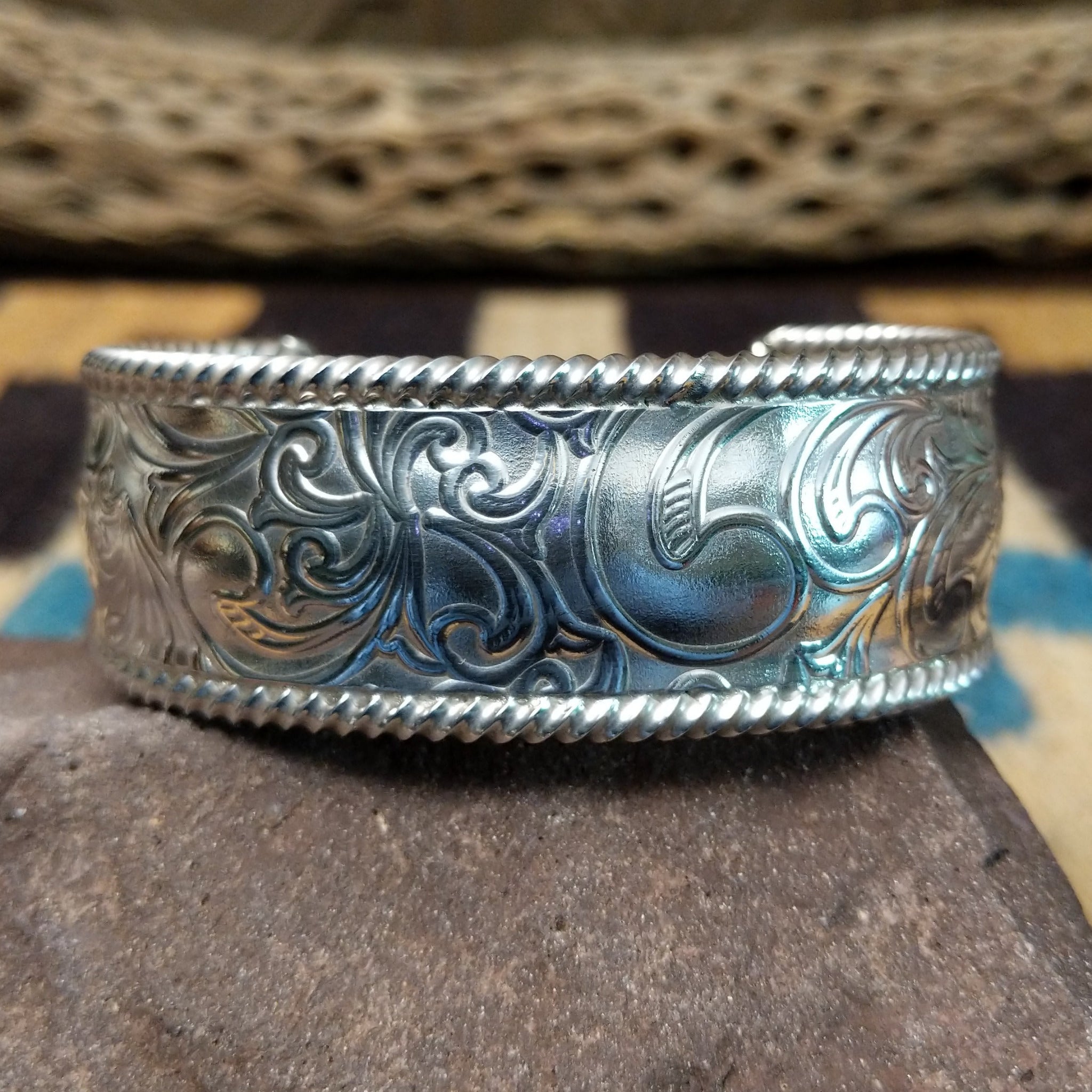 Silver filigree cuff by Larry Joe, featuring hand-engraved scrollwork framed by twisted rope borders on a handcrafted wide sterling silver open cuff.