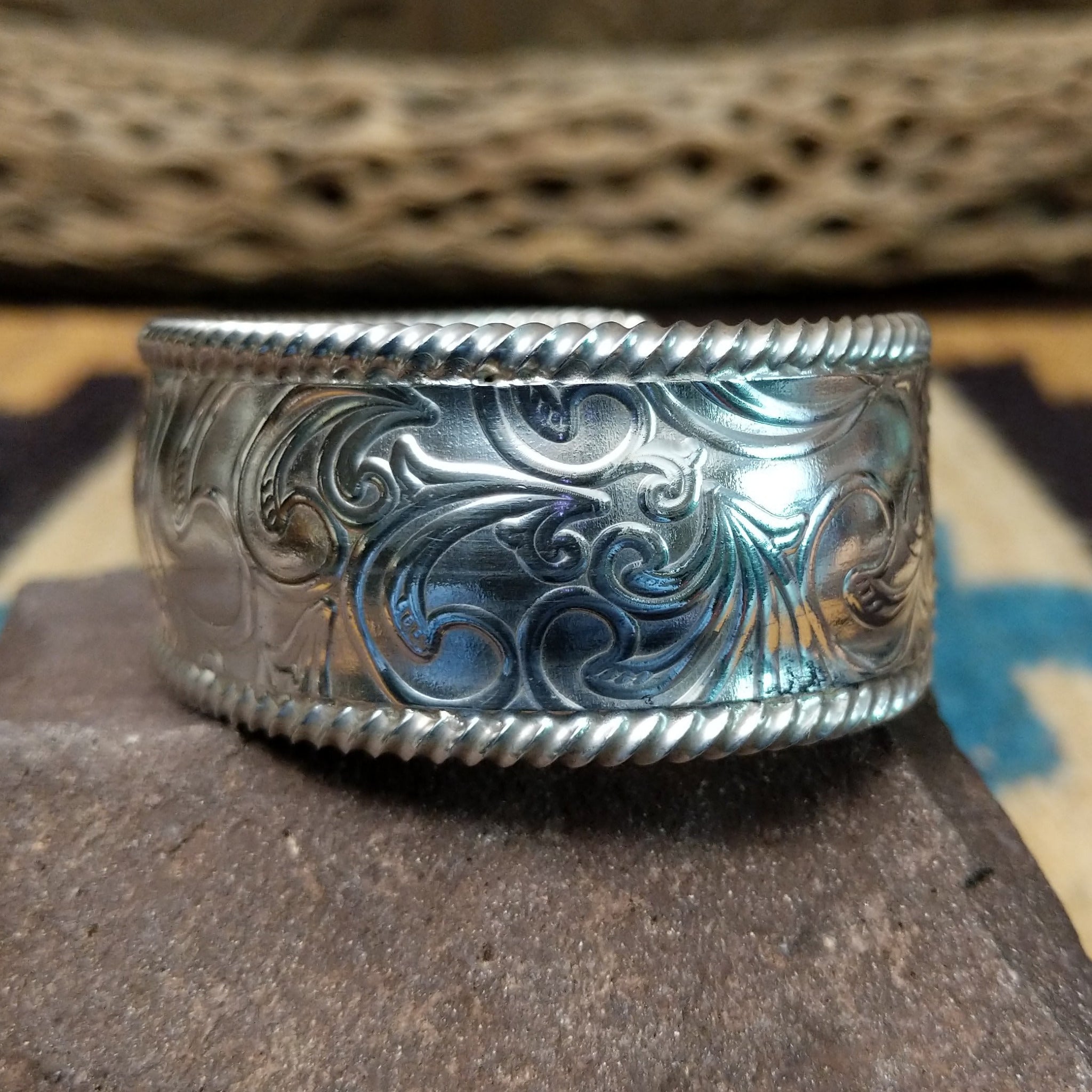 Silver filigree cuff by Larry Joe, featuring hand-engraved scrollwork framed by twisted rope borders on a handcrafted wide sterling silver open cuff.