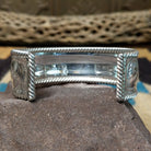 Silver filigree cuff by Larry Joe, featuring hand-engraved scrollwork framed by twisted rope borders on a handcrafted wide sterling silver open cuff.  Underside view.