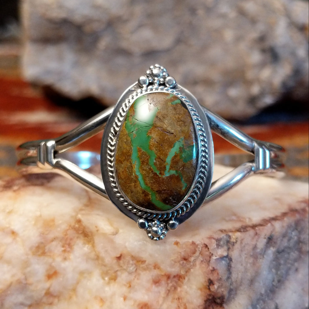 Sterling silver cuff with framed turquoise set within a twisted rope bezel.