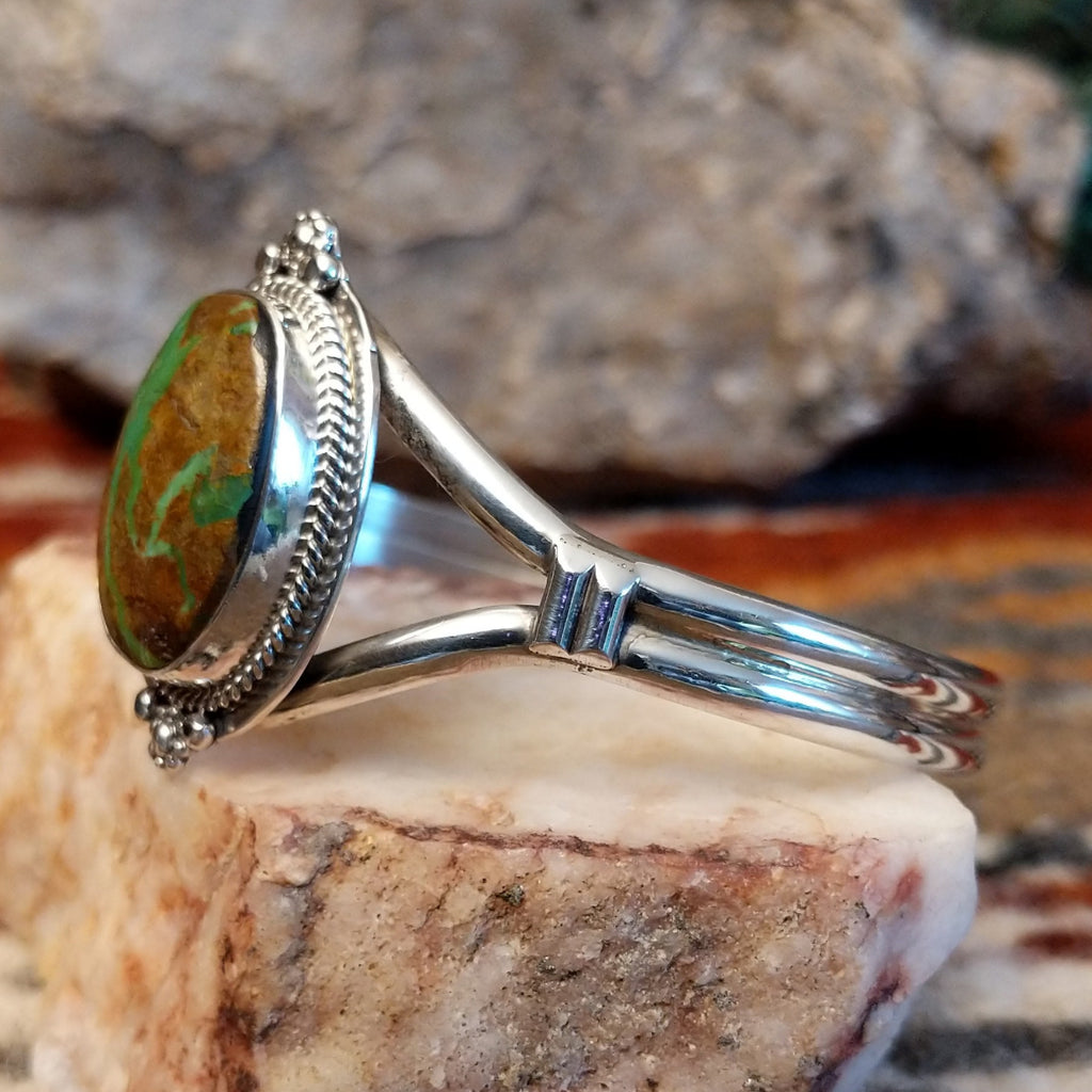 Sterling silver cuff with framed turquoise set within a twisted rope bezel.