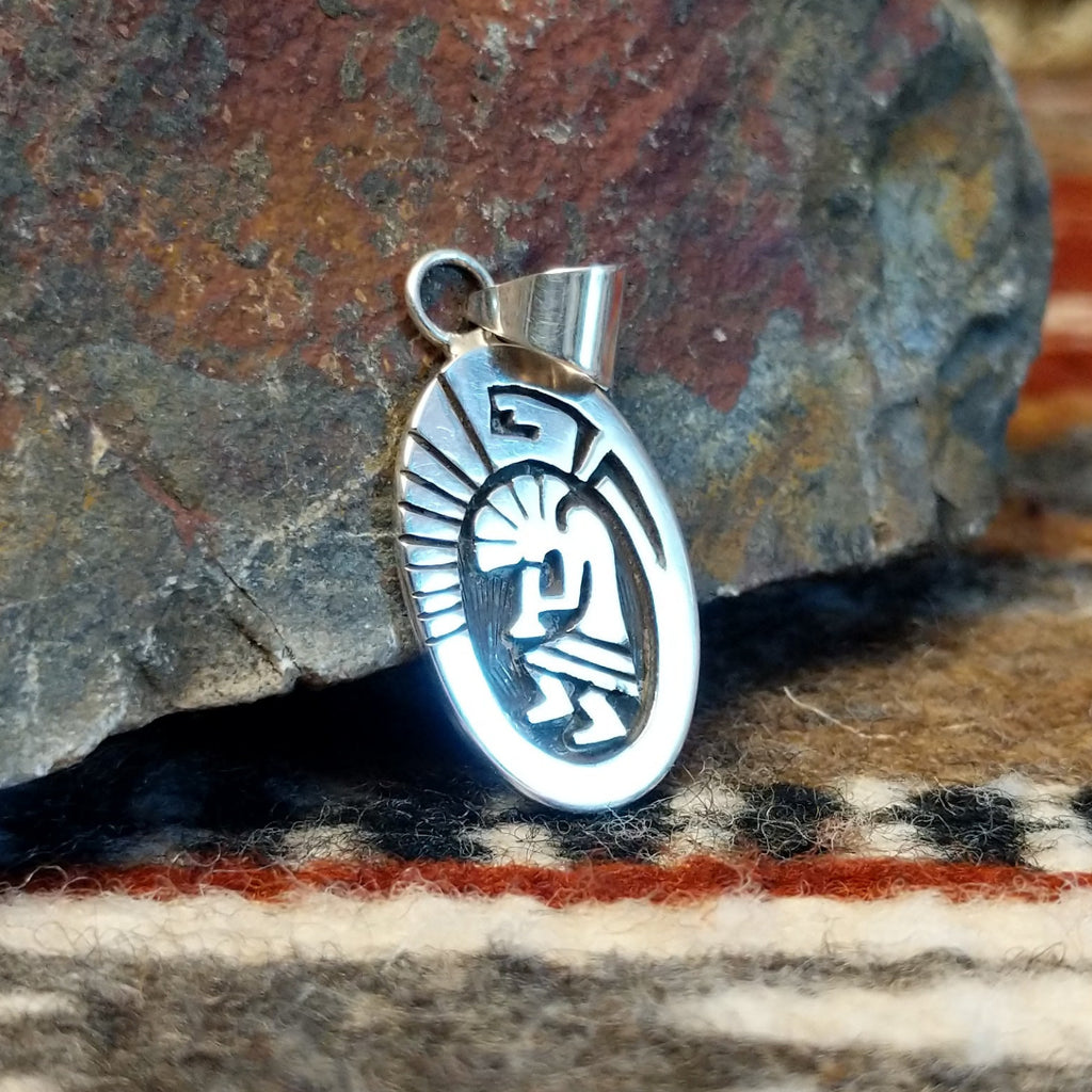 Small oval sterling silver pendant with Kokopelli design.