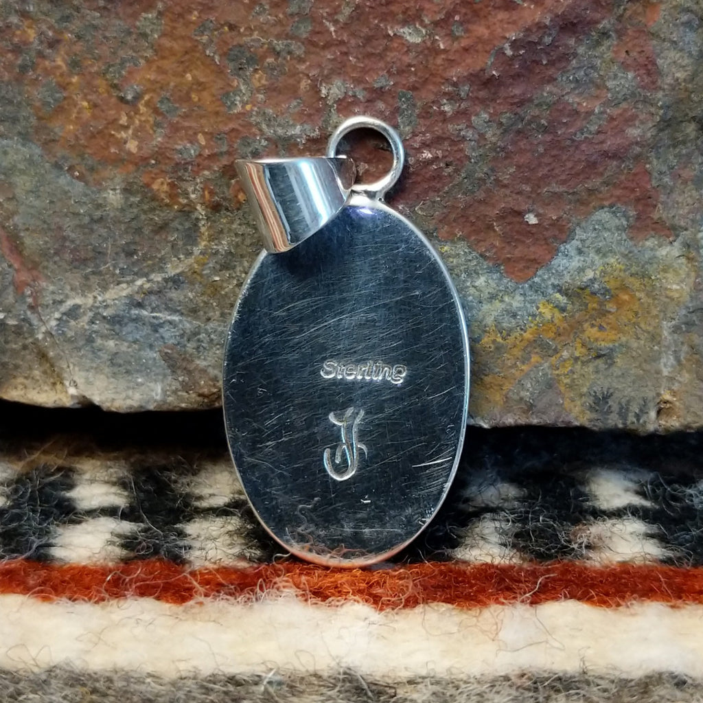 The back features the artisan's signature.