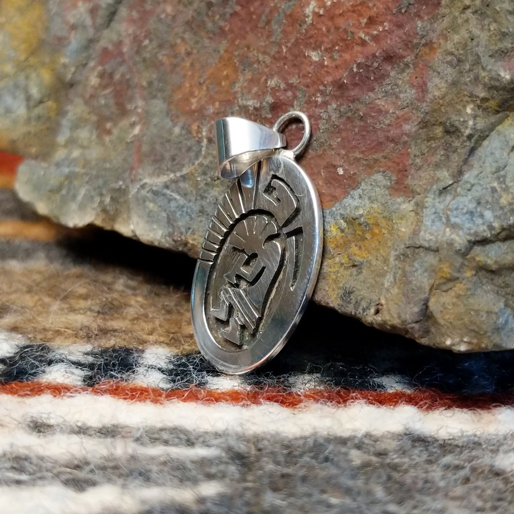 Small oval sterling silver pendant with Kokopelli design.