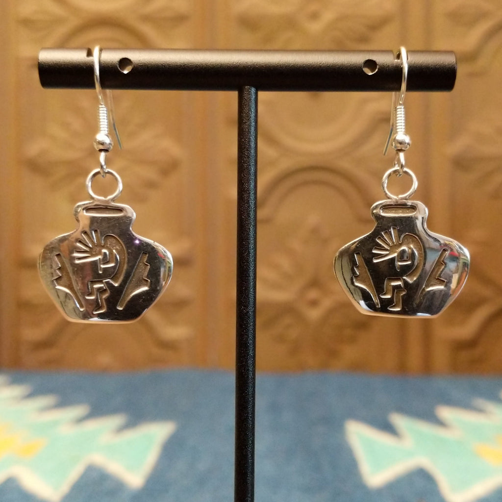 Sterling silver dangle earrings shaped into pots with kokopelli designs on the surface.