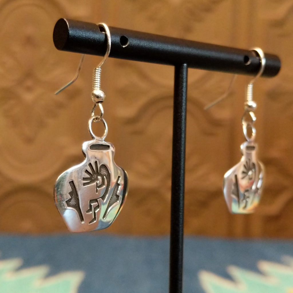 Sterling silver dangle earrings shaped into pots with kokopelli designs on the surface.