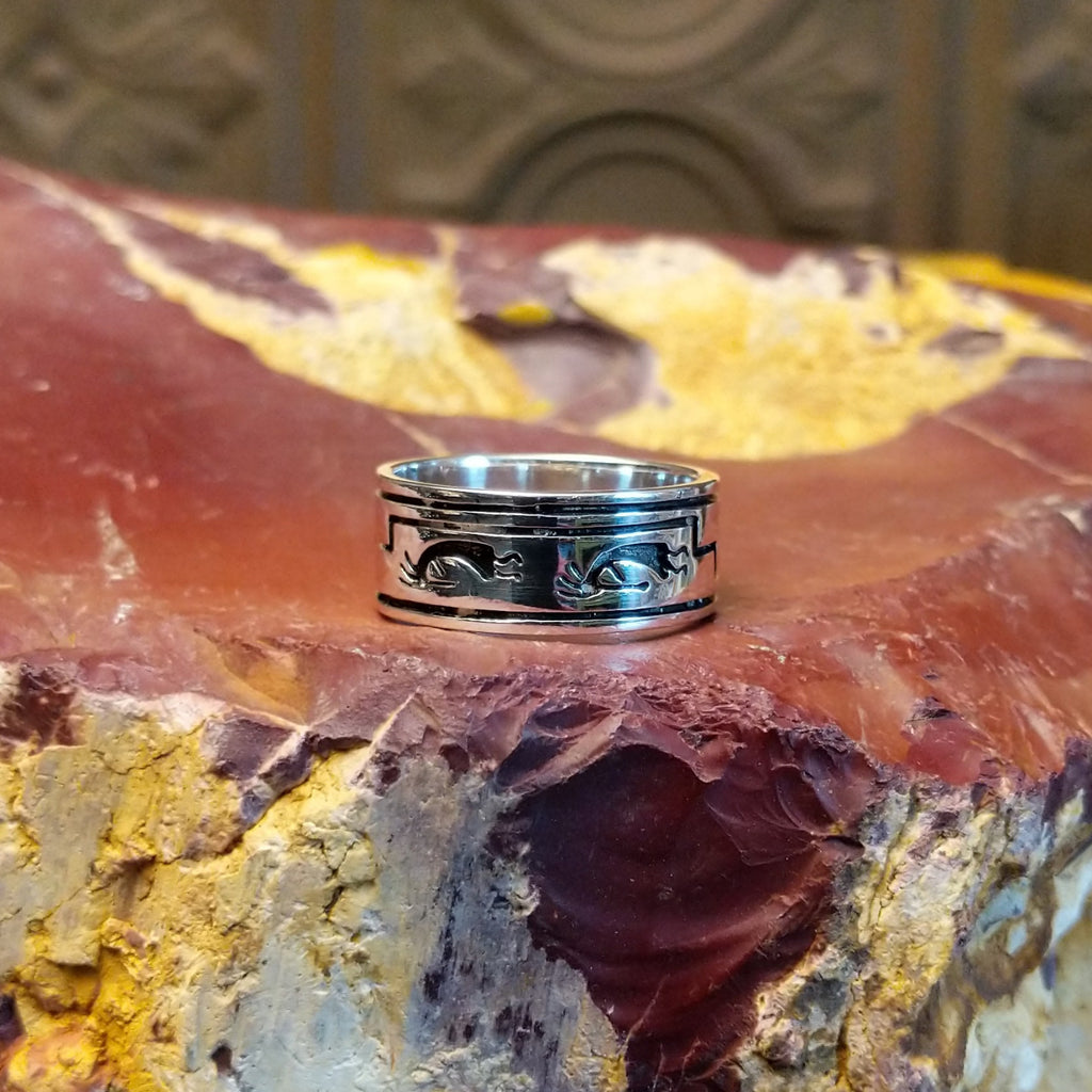 Sterling silver ring with kokopelli figures stamped all along the band.