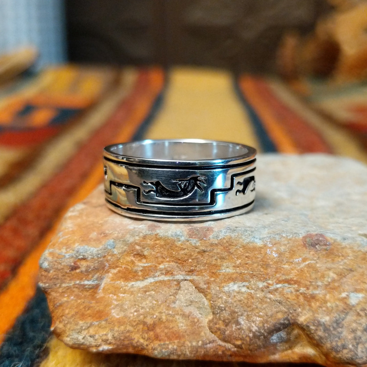Silver Kokopelli Ring by Irene Kee featuring a wide polished silver band with a flute-playing Kokopelli figure, geometric Southwestern patterns, oxidized detailing, and smooth silver edges.