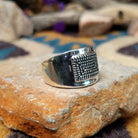 Sterling silver ring by Raymond Coriz with a rectangular hand-stamped geometric design; side view.