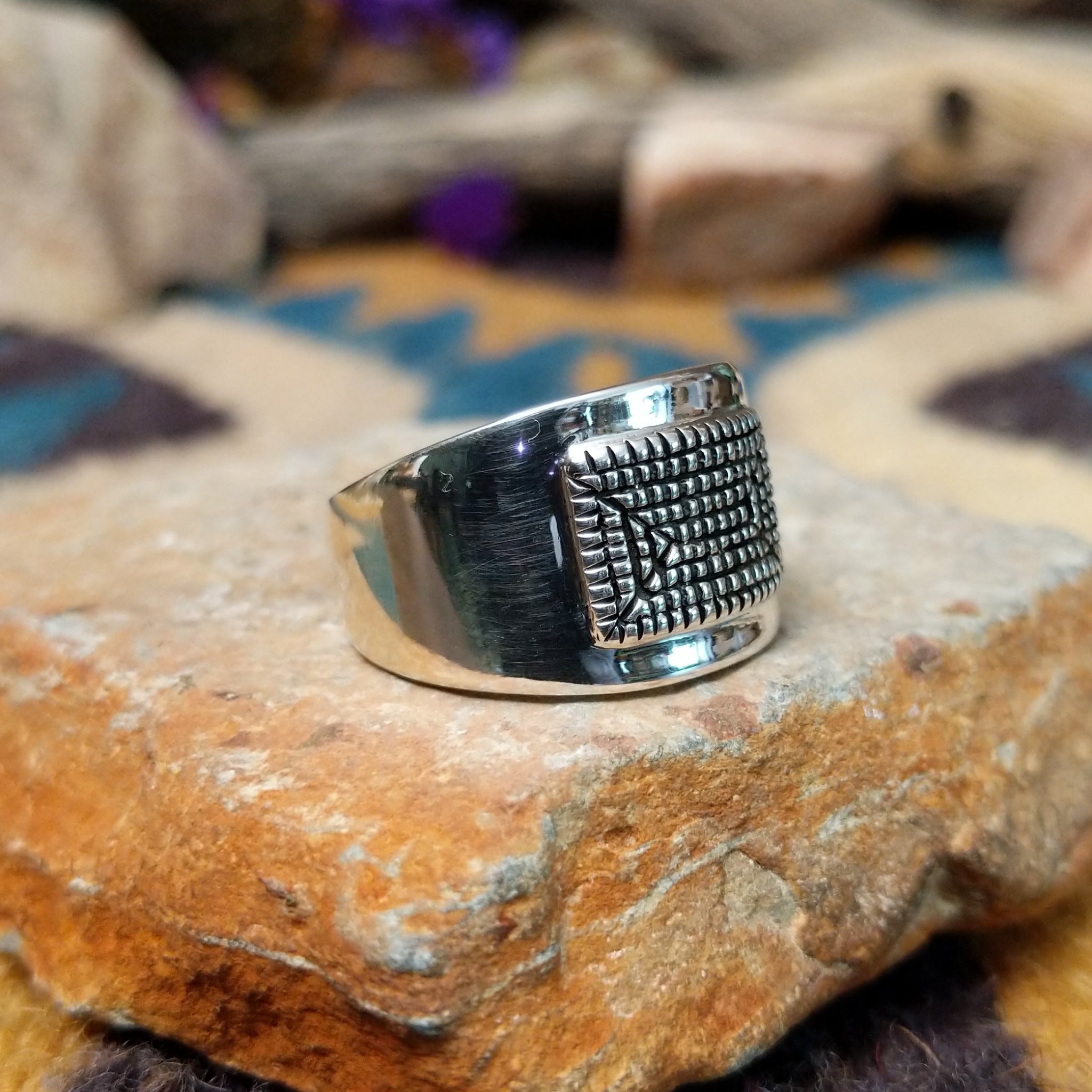 Sterling silver ring by Raymond Coriz with a rectangular hand-stamped geometric design; side view.