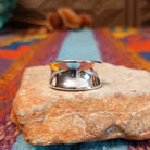 Polished silver saddle ring by Raymond Coriz with broad curved face.
