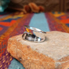 Polished silver saddle ring by Raymond Coriz with broad curved face.