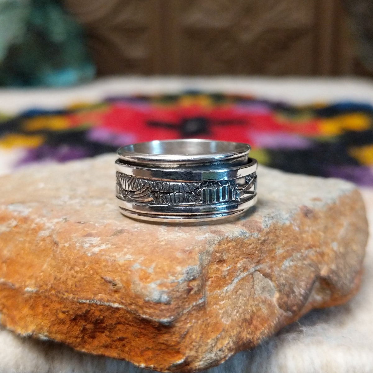 Silver spinner ring by Elaine Becenti with stamped geometric designs and layered movable bands.