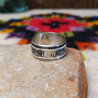 Silver spinner ring by Elaine Becenti with stamped geometric designs and layered movable bands.
