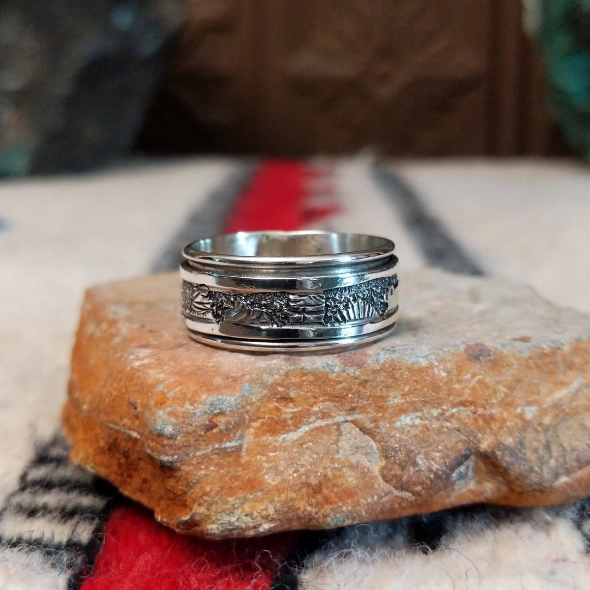 Silver spinner ring by Elaine Becenti with stamped rotating outer band.