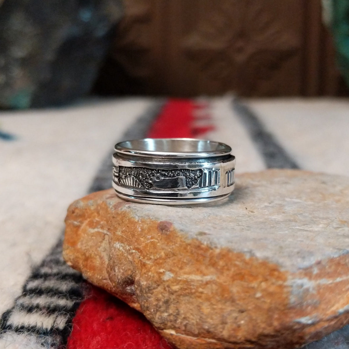 Silver spinner ring by Elaine Becenti with stamped rotating outer band.
