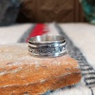 Silver spinner ring by Elaine Becenti with stamped rotating outer band.