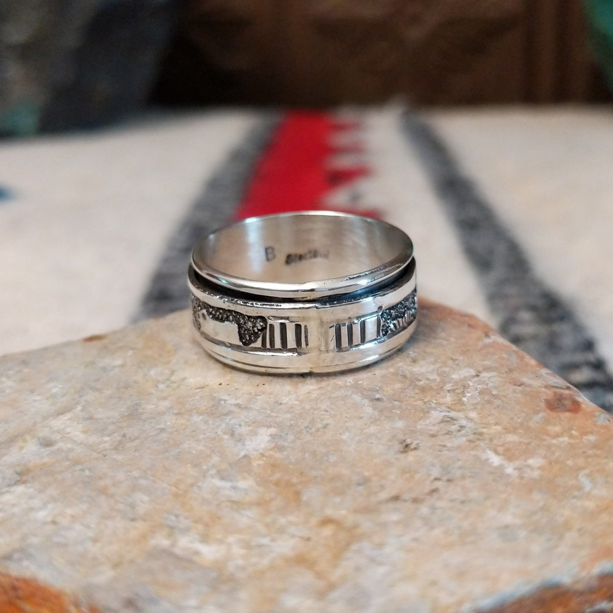 Silver spinner ring by Elaine Becenti with stamped rotating outer band.